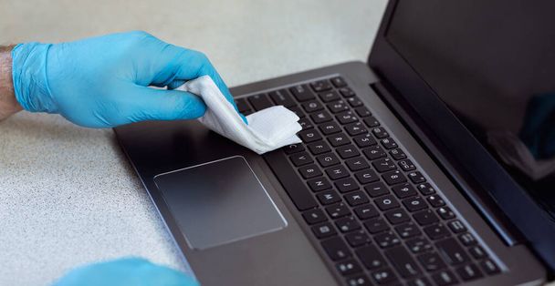 Απολυμαίνοντας το Laptop Φορώντας Ιατρικά Γάντια Στο Σπίτι, Κοντινό πλάνο, Πανόραμα - Φωτογραφία, εικόνα