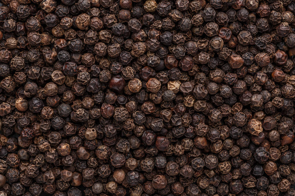 Peppercorn background. Dry black pepper seeds. Top view. Flat design. Macro spice background - Фото, изображение