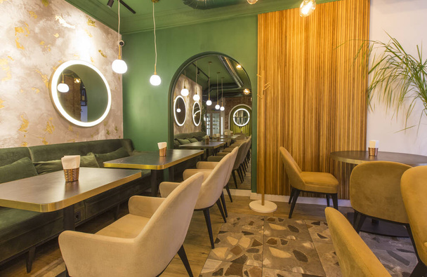 Μοντέρνο εσωτερικό εστιατορίου με τραπεζάκια και καναπέδες, ανοιχτόχρωμοι πράσινοι τοίχοι - Φωτογραφία, εικόνα