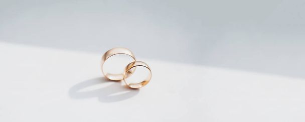 Close-up of wedding golden rings on white table. - Фото, изображение