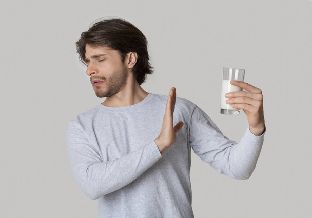 Mann mit Milchallergie und Glas Milch - Foto, Bild