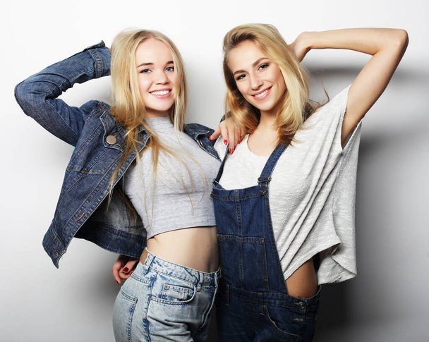 Two young girl friends standing together and having fun - Valokuva, kuva