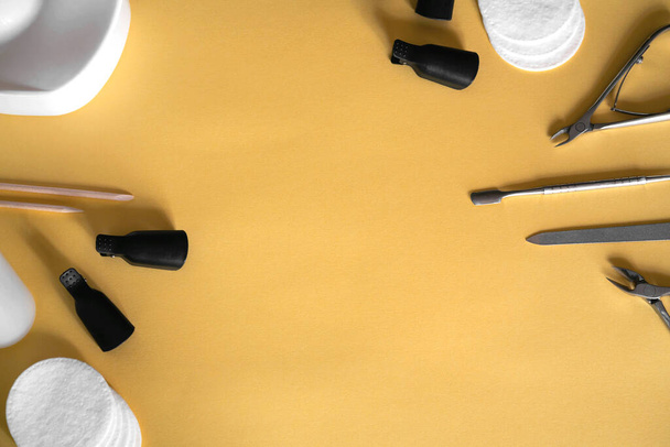 Maniküre-Werkzeuge auf pastellgelbem Hintergrund. Zangen, Nagelfeile, Drücker, Wattepads. Maniküre zu Hause. - Foto, Bild