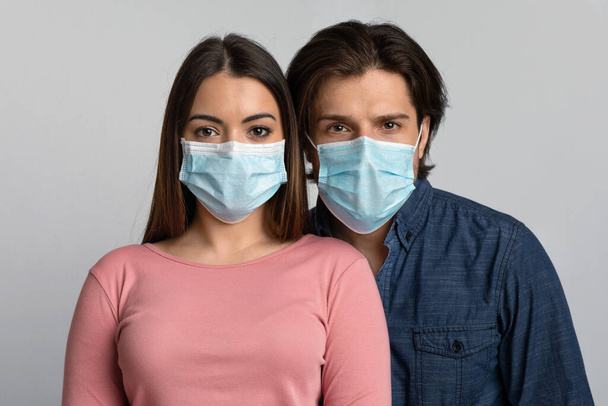 Portrait de jeune homme et femme portant des masques médicaux regardant la caméra
 - Photo, image