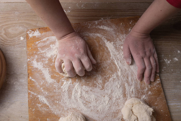 Female hands mixing dough in the home kitchen - Photo, image