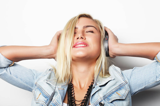 Pretty young girl enjoys listening music - Photo, image