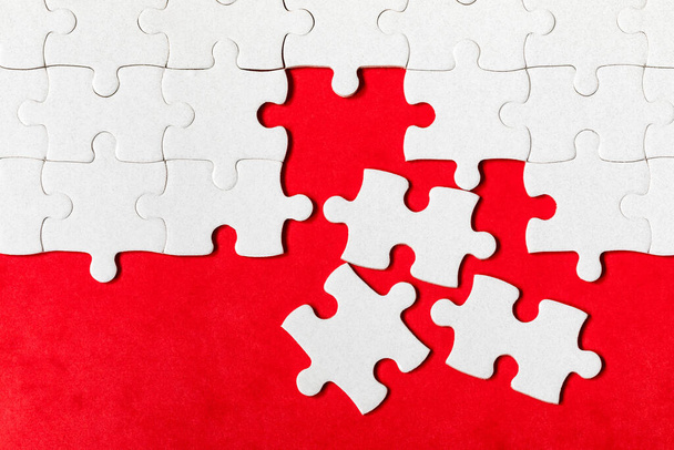 White jigsaw puzzle. White puzzle pieces on color background. Unfinished white jigsaw puzzle pieces on color background.  - 写真・画像