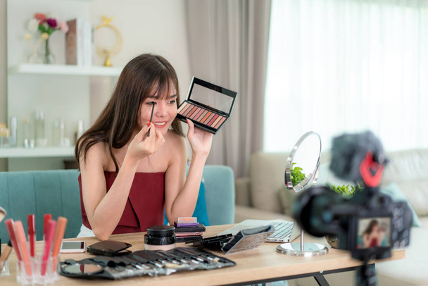アジアの女性vloggerプレゼントや教育は、彼女の顔に美容化粧品製品を構成し、自宅でインターネットによってソーシャルネットワークにライブビデオを放送,美容ブロガーの概念. - 写真・画像