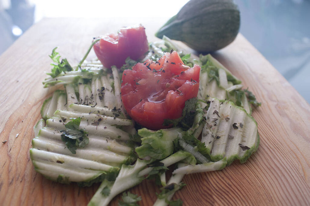 Salade végétalienne à base de courgettes vertes et tomates rouges avec des herbes de basilic et coriandre gourment alimentaire
 - Photo, image