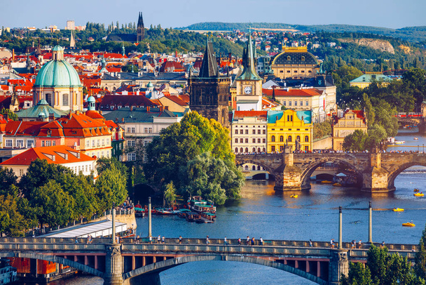 チェコ共和国プラハのヴルタヴァ川にかかる旧市街の桟橋建築とカレル橋の風景。プラハの象徴的なカレル橋(カルロヴィ・ヴァリ)と旧市街橋塔は、チェコの日没時に建てられました。. - 写真・画像