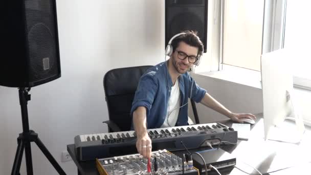 Young man in sound recording studio. Playing music and equipment concept. Hands using mixing console. Enjoying recording process. - Footage, Video