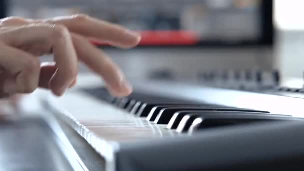 Mladý muž v nahrávacím studiu. Detailní záběr z ruky hrající na klavír klávesnice s pravou rukou. Učím se hrát na elektronickém syntezátoru. Student. - Záběry, video