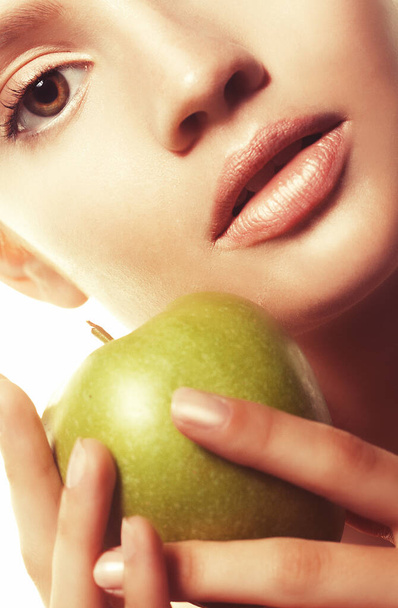 Head shot of woman holding green apple against white background - Zdjęcie, obraz