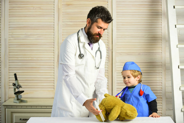 Father and kid with busy faces play doctor. - Фото, зображення