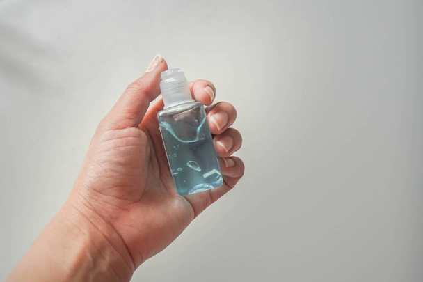 foyer sélectif main de femme avec bouteille d'alcool pour le nettoyage dans la crise Covid-19 et les soins de santé
 - Photo, image