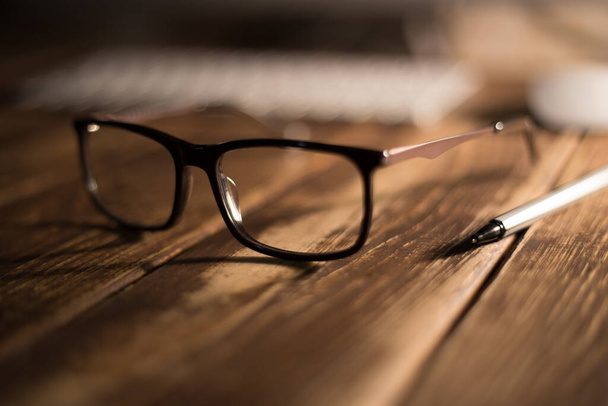 Brille für Seh- und Sehkorrektur und Schutz vor dem Computer auf dem Holztisch - Foto, Bild