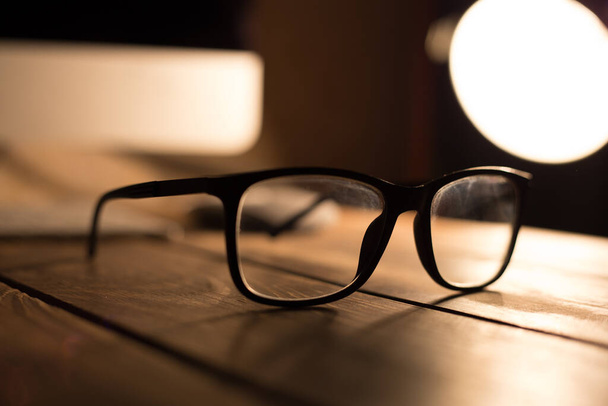 Okulary do korekcji wzroku i wzroku oraz ochrony przed komputerem na drewnianym stole - Zdjęcie, obraz