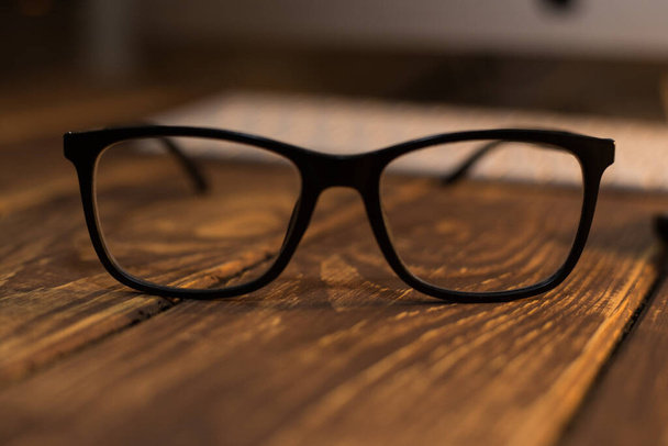 Okulary do korekcji wzroku i wzroku oraz ochrony przed komputerem na drewnianym stole - Zdjęcie, obraz
