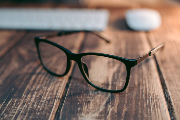 Brille für Seh- und Sehkorrektur und Schutz vor dem Computer auf dem Holztisch - Foto, Bild