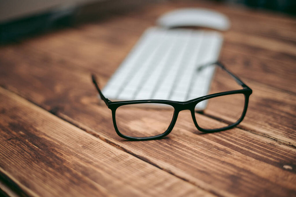 Brýle pro korekci zraku a zraku a ochranu před počítačem na dřevěném stole na klávesnici - Fotografie, Obrázek