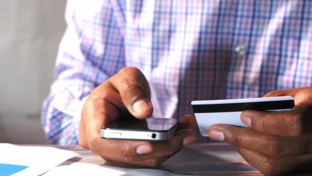Homem segurando cartão de crédito e usando telefone inteligente, conceito de compras on-line
 - Filmagem, Vídeo