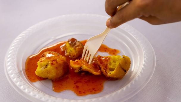 Cucur Udang ou beignets de crevettes recouverts de sauce chili sur fond blanc isolé, c'est un gâteau à l'heure du thé commun parmi les Malaisiens.
. - Photo, image