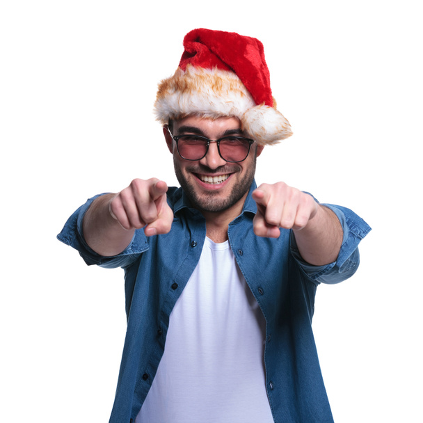 людина в капелюсі Санта вказує свої пальці
 - Фото, зображення