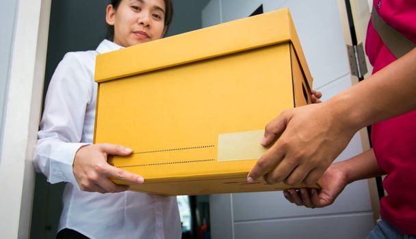 Aasia nainen saavat laatikon toimitus mies lähetys online-ostoksia toimitus palvelukonsepti
 - Valokuva, kuva