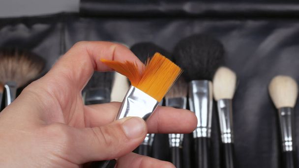 makeup brush in the hands of a makeup artist, beauty - 写真・画像
