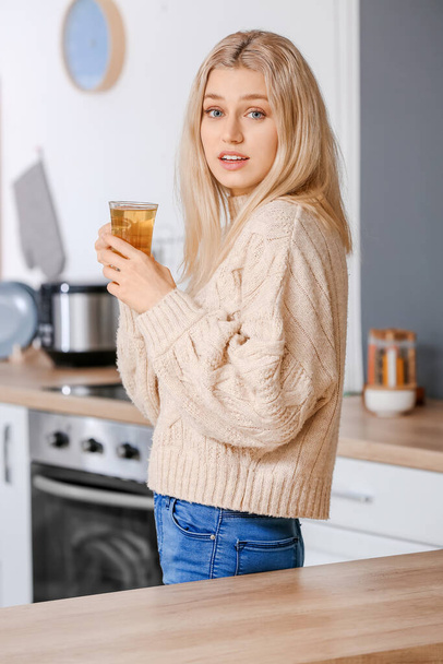 Mooie jonge vrouw die thuis thee drinkt - Foto, afbeelding