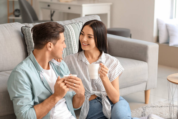 Feliz joven pareja bebiendo té en casa
 - Foto, Imagen