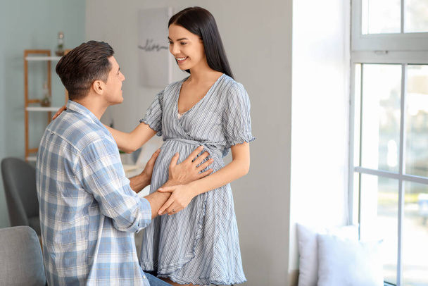Retrato de pareja embarazada feliz en casa
 - Foto, Imagen