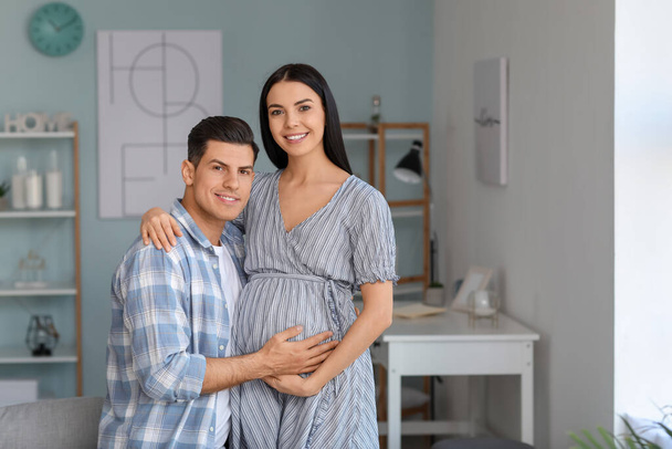 Портрет счастливой беременной пары дома
 - Фото, изображение
