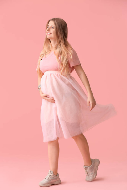 Красивая беременная женщина на цветном фоне
 - Фото, изображение
