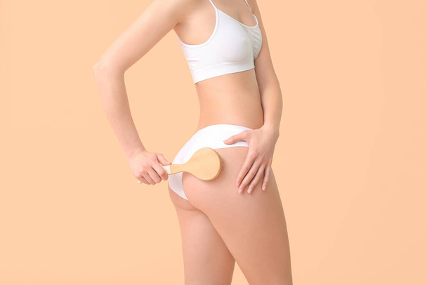 Woman with anti-cellulite massage brush on color background - Foto, imagen