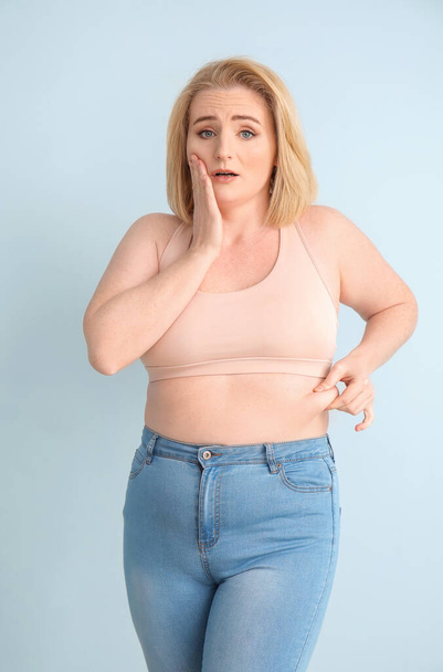 Προβληματική υπέρβαρη γυναίκα στο φόντο χρώμα - Φωτογραφία, εικόνα