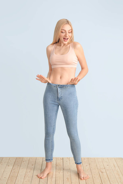 Happy slim woman on color background - Photo, Image