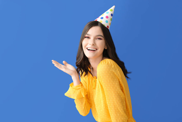 Όμορφη νεαρή γυναίκα γιορτάζει γενέθλια στο φόντο χρώμα - Φωτογραφία, εικόνα