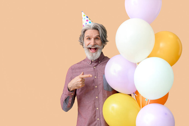 Uomo anziano che celebra il compleanno sullo sfondo di colore
 - Foto, immagini