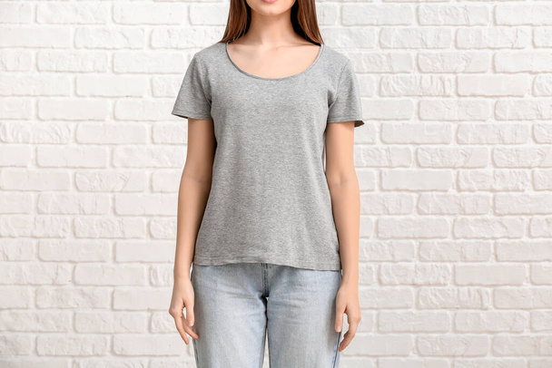 Young woman in stylish t-shirt on white background - Fotó, kép