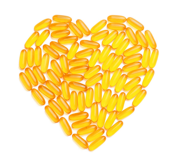 Heart made of fish oil capsules on white background - Foto, Bild