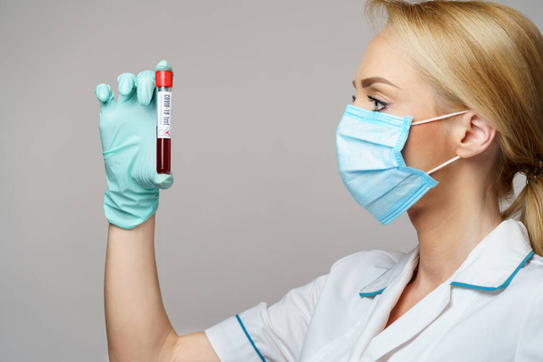 medical doctor nurse woman wearing protective mask and gloves - holding virus blood test - Foto, afbeelding
