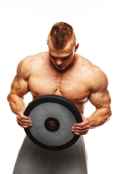 Komea mies, jolla on lihaksikas vartalo nostopainot
 - Valokuva, kuva