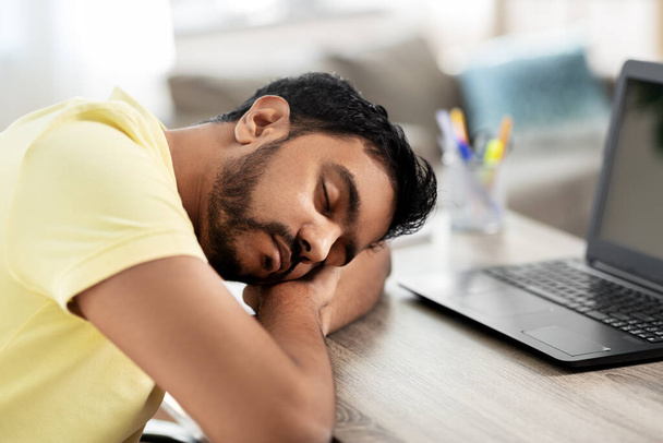 indian man sleeping on table with laptop at home - Foto, immagini