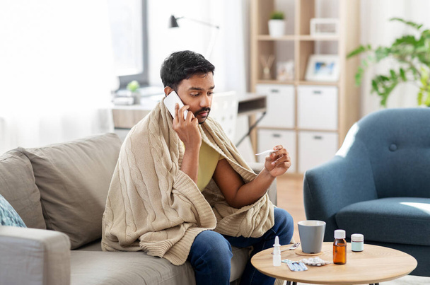 sick man with thermometer calling on smartphone - Photo, image