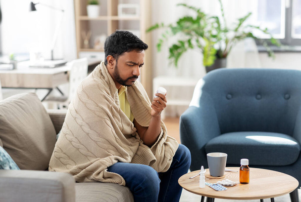 triste hombre enfermo en manta con la medicina en casa - Foto, imagen