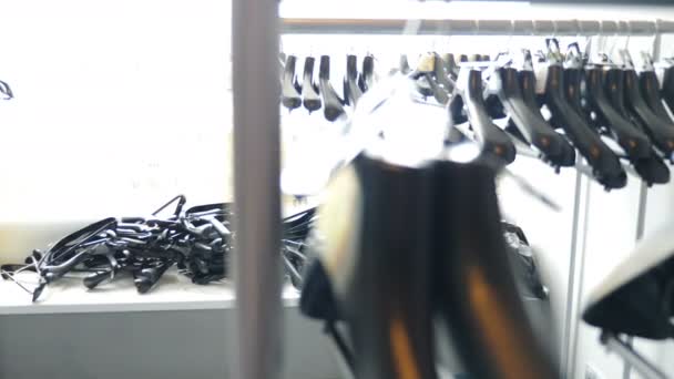 Empty black clothes hangers. Hangers arranged on clothes rack against white window. close-up shot. Other hangers lying on window sill. Nothing to wear, Closed mall, shop and fashion boutique. 4 k - Footage, Video