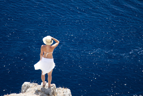 girl in a white skirt stands on the edge of a cliff - Fotografie, Obrázek