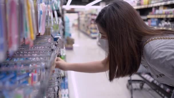 Asiatin trägt Maske beim Einkaufen im Supermarkt, deckt sich mit Lebensmitteln ein, Lebensstil während Covid19 Coronavirus, häusliche Quarantänezubereitung, gesunde Auswahl, weltweite Pandemiekrise, ein Frauenmodell - Filmmaterial, Video