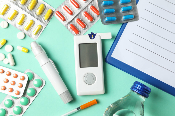 Diabetes accessories on mint background, top view - Fotó, kép